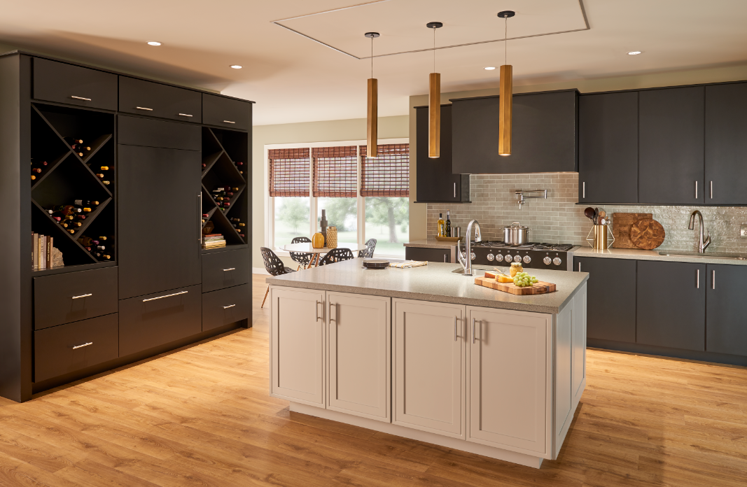 Kitchen scene featuring hardwood floors, quartz kitchen island, black cabinetry and tile backsplash.