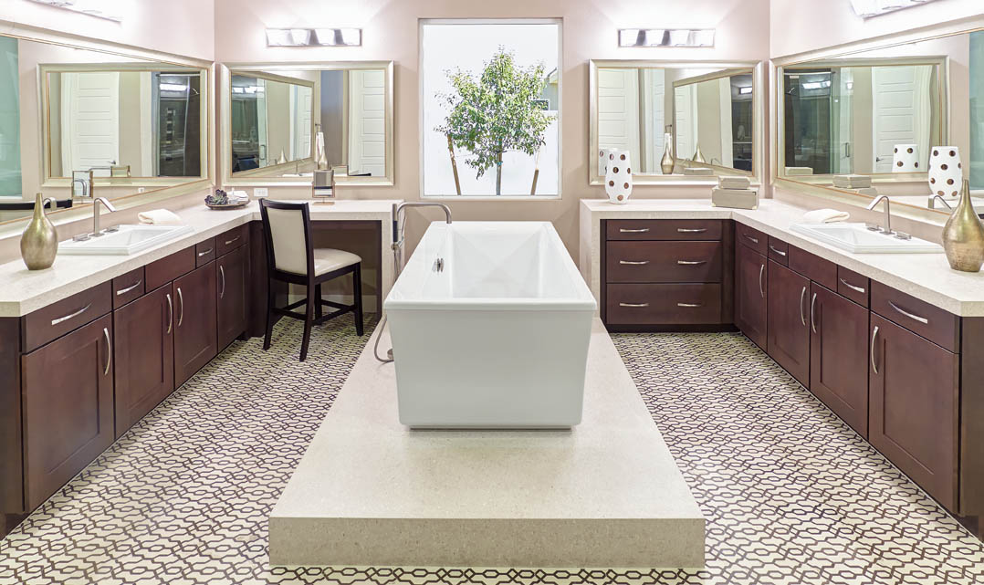 Bathroom scene with claw tub in room center, tile floor, wrap around bath sinks and cabinetry